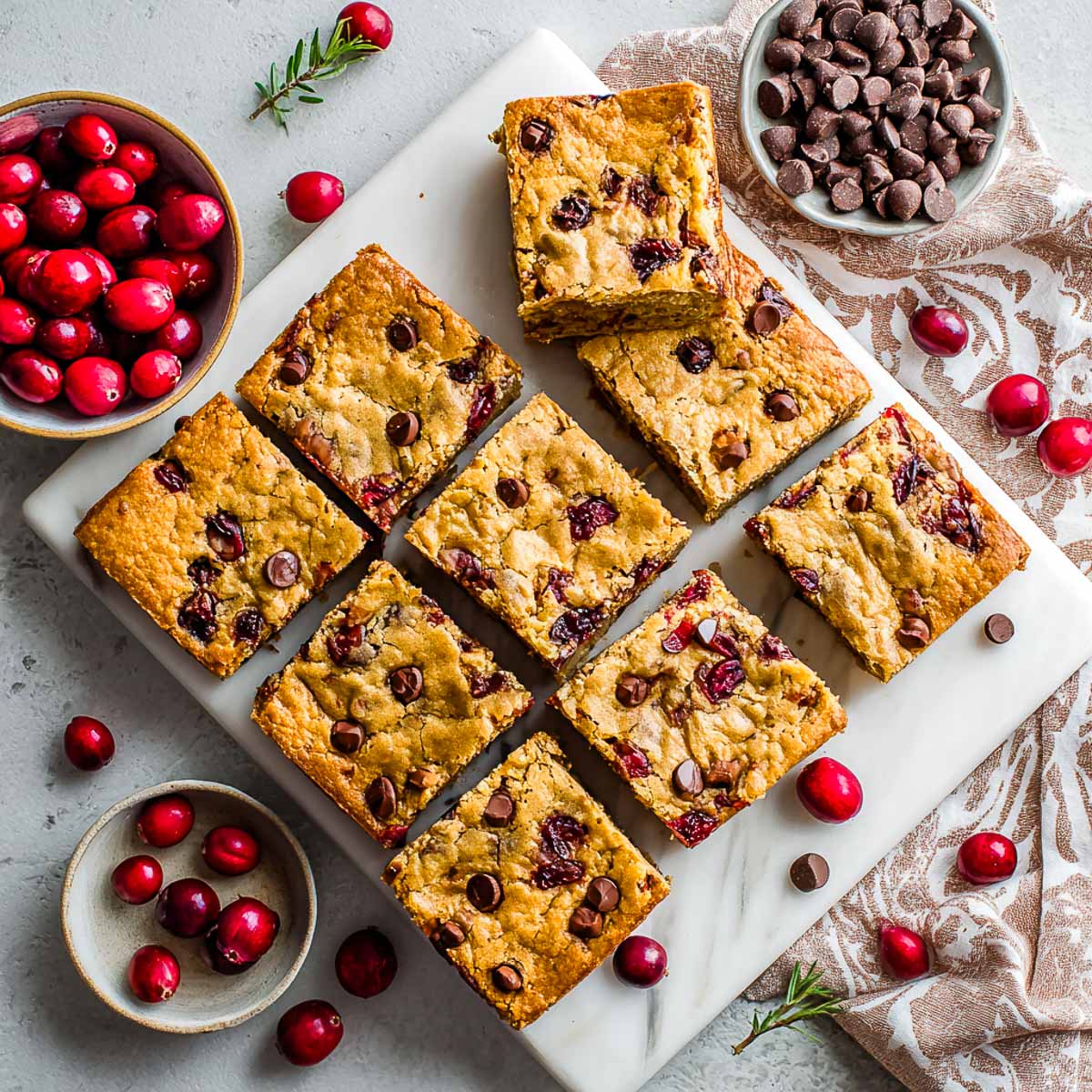 Sliced gluten-free cranberry chocolate chip blondies on a tray.