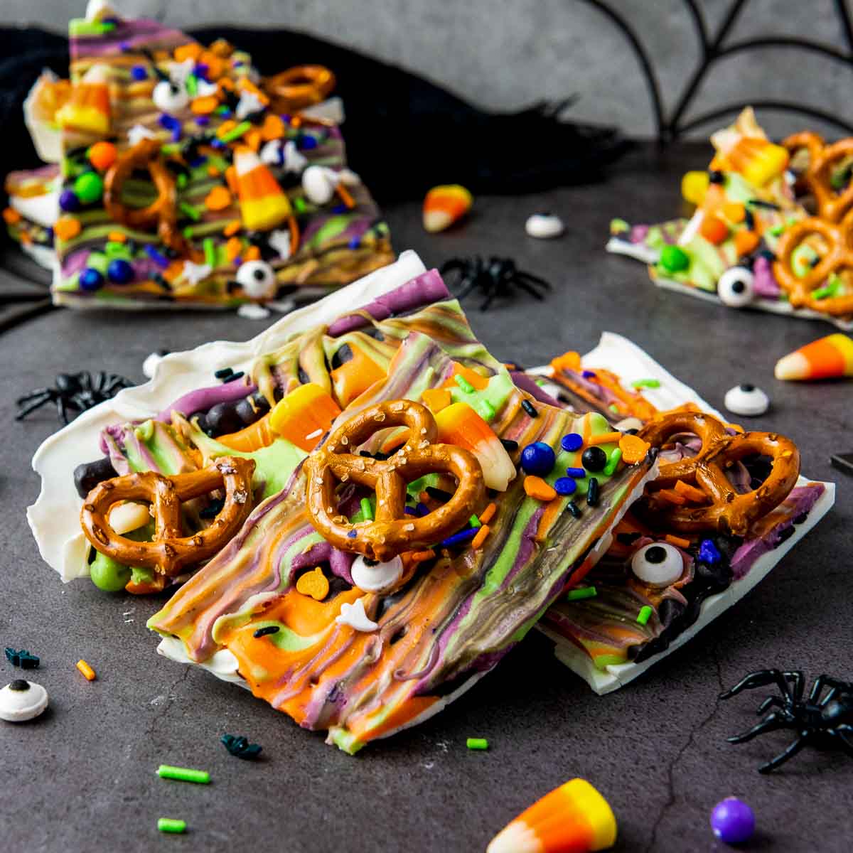 Colorful Halloween candy bark topped with pretzels, candy corn, and sprinkles.