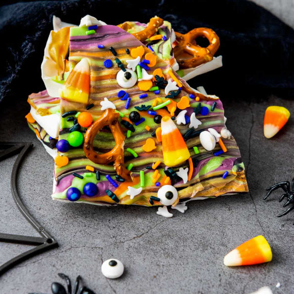 Close-up of Halloween bark with candy corn, pretzels, and spooky sprinkles.