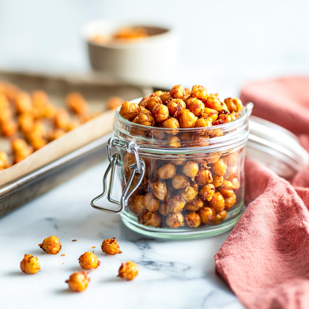 Crunchy roasted masala chickpeas stored in a glass jar after baking.
