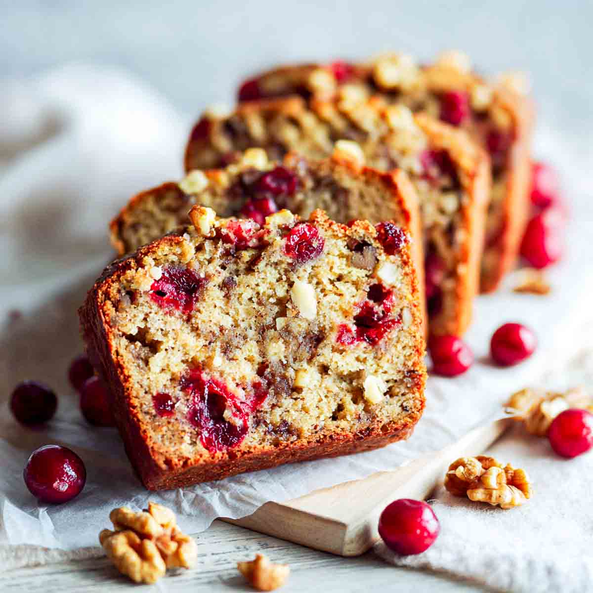 Banana cranberry bread sliced and placed on a marble surface.