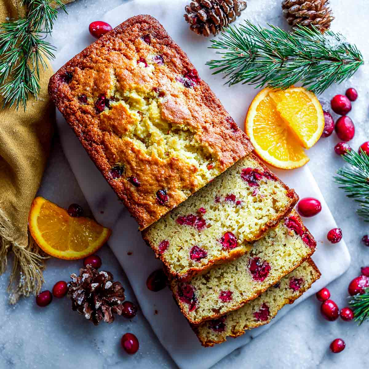 Top down view of gluten-free cranberry orange bread with almond flour, golden crust, cranberries inside.