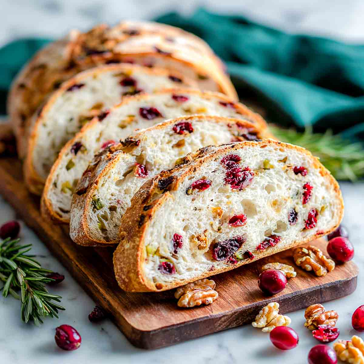 Sliced cranberry honey walnut bread on a wooden board.