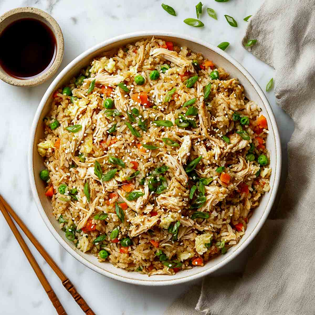 Leftover turkey fried rice with peas, carrots, and green onions in a white bowl.