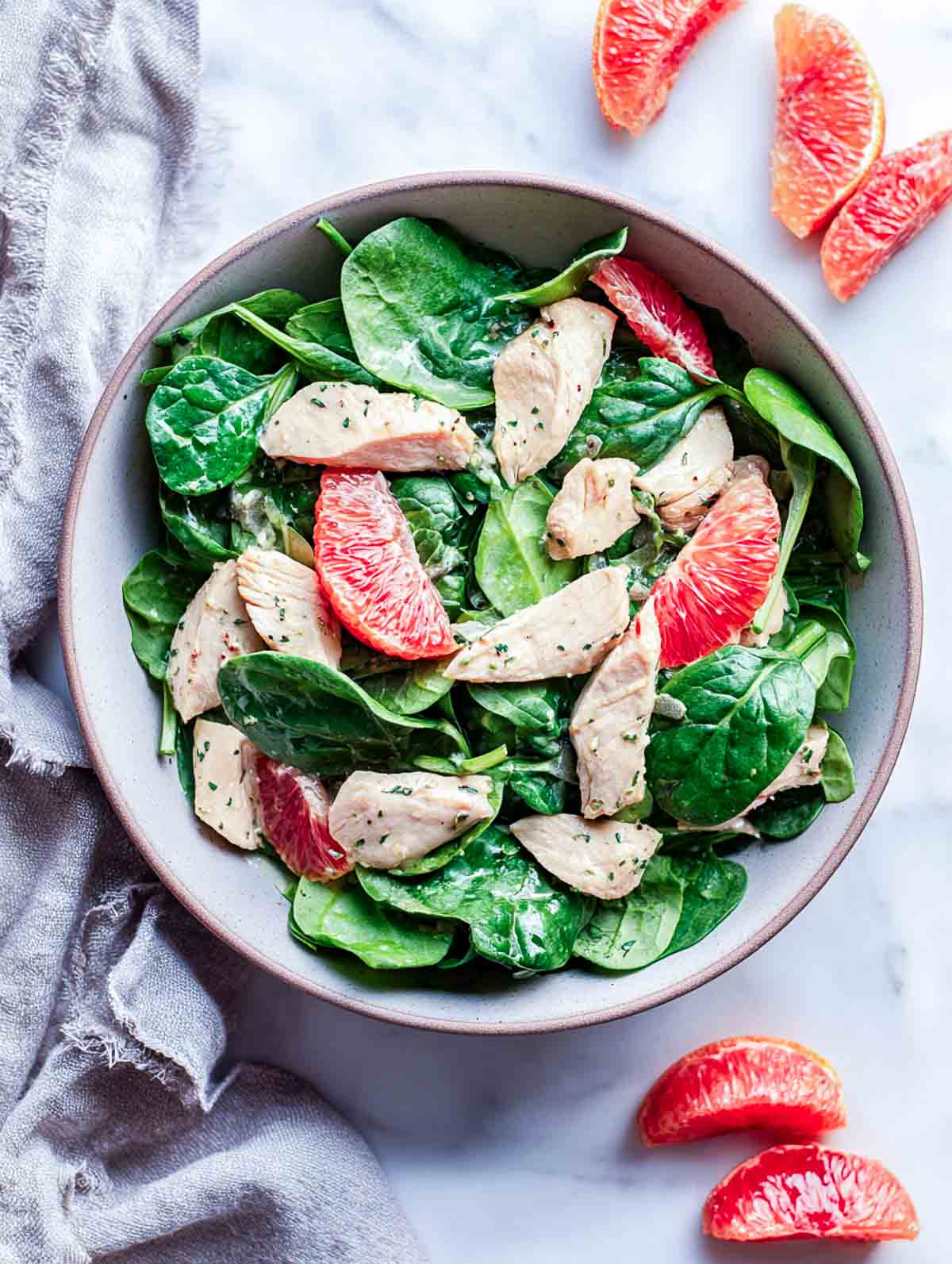 Spinach chicken salad with blood orange segments and citrus-brined chicken strips.