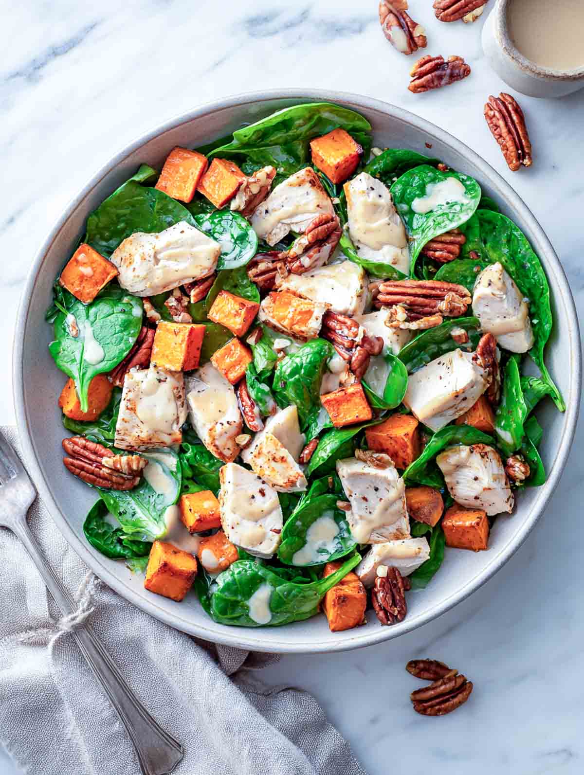 Warm spinach chicken salad with sweet potato chunks, pecans, and maple Dijon dressing.