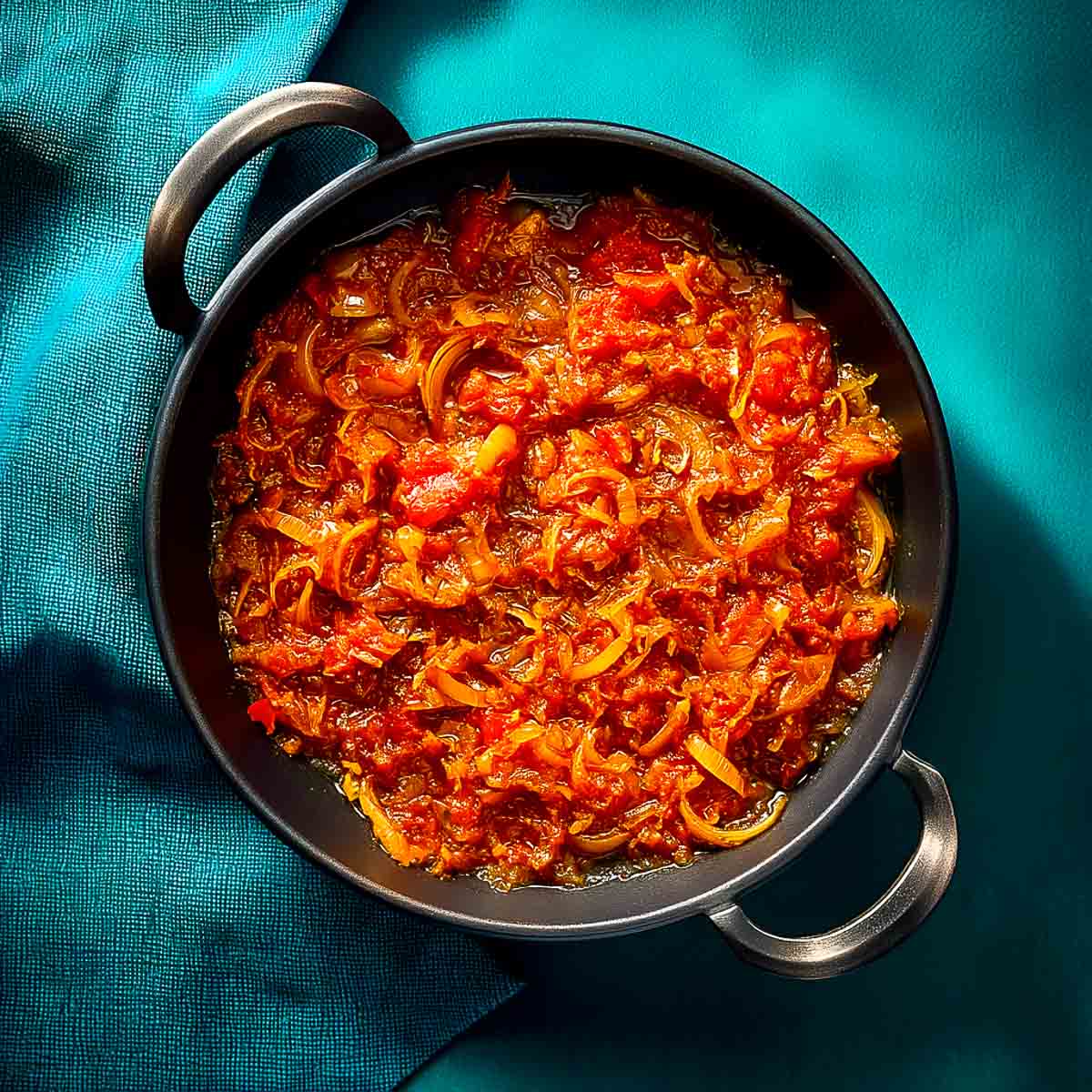 Cooked onions and tomatoes simmering together into a thick, glossy masala base.