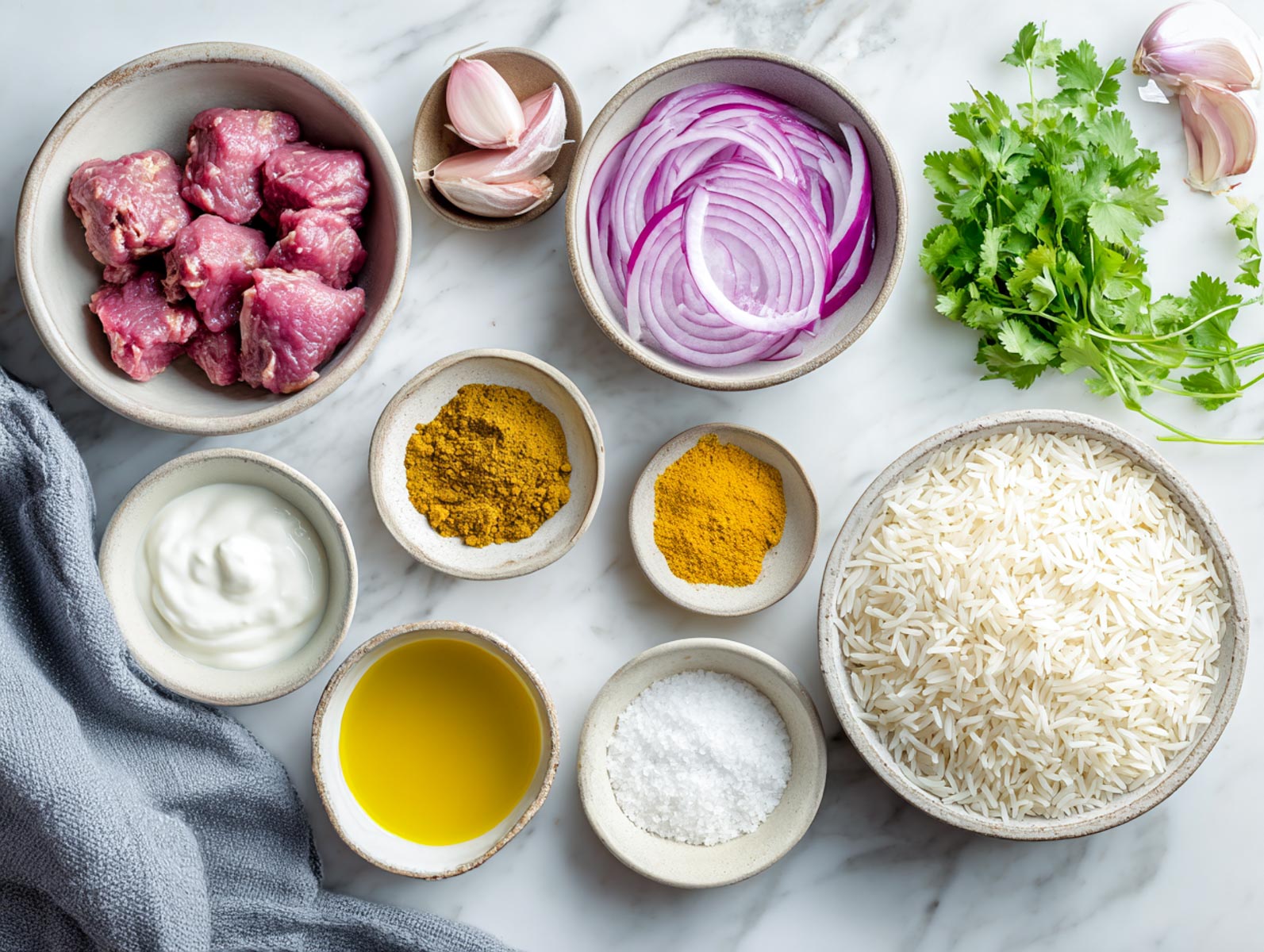 Raw lamb, basmati rice, onions, yogurt, spices, and herbs arranged neatly.
