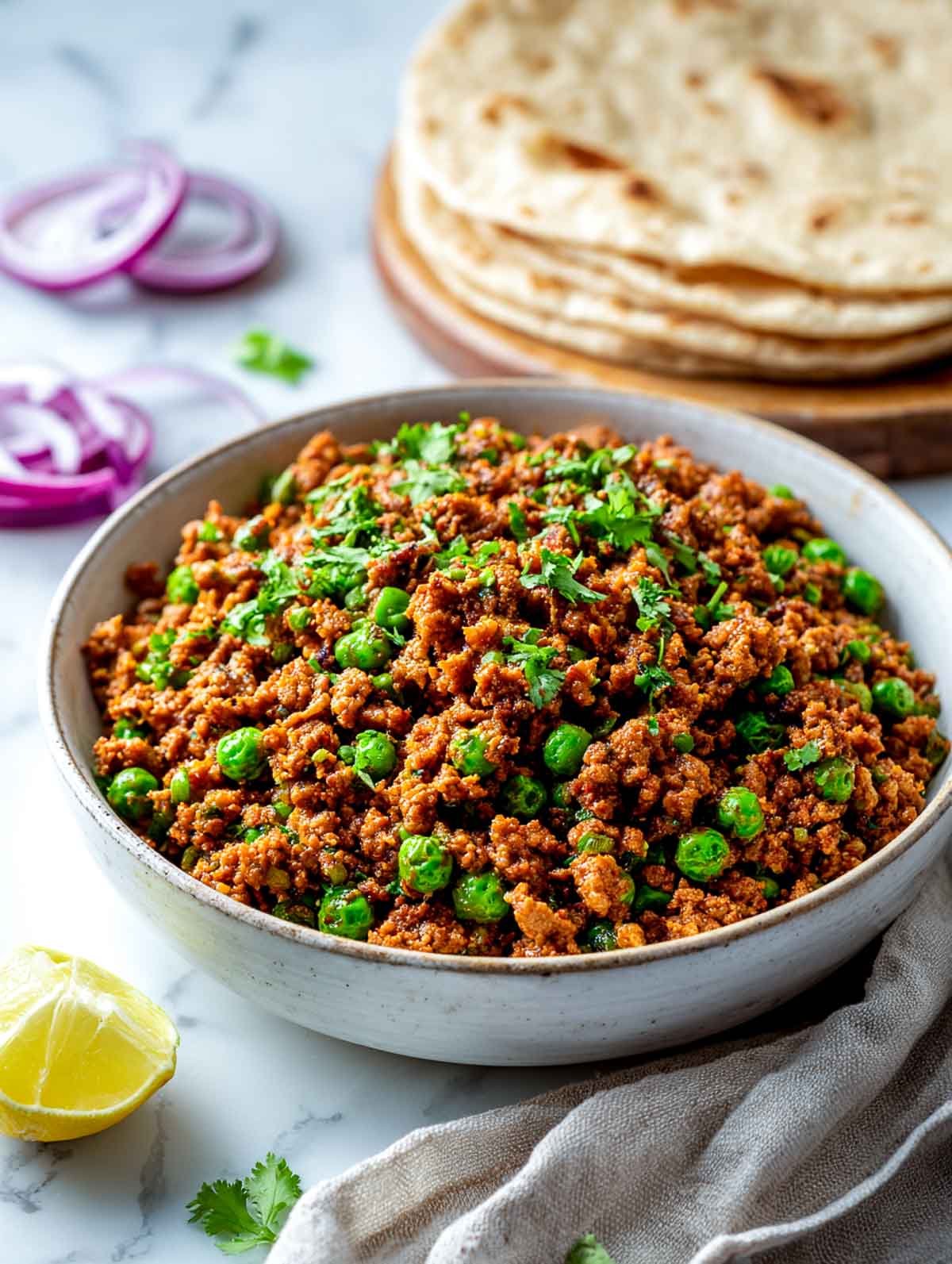Punjabi-style dry lamb keema with peas is garnished with fresh chopped cilantro.