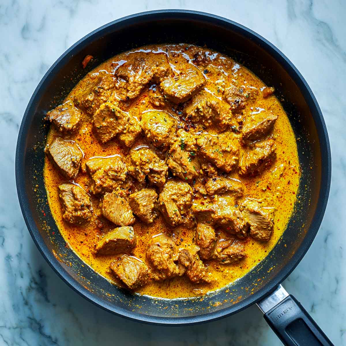 Yogurt and spices mixed into sautéed lamb as the korma base begins forming.