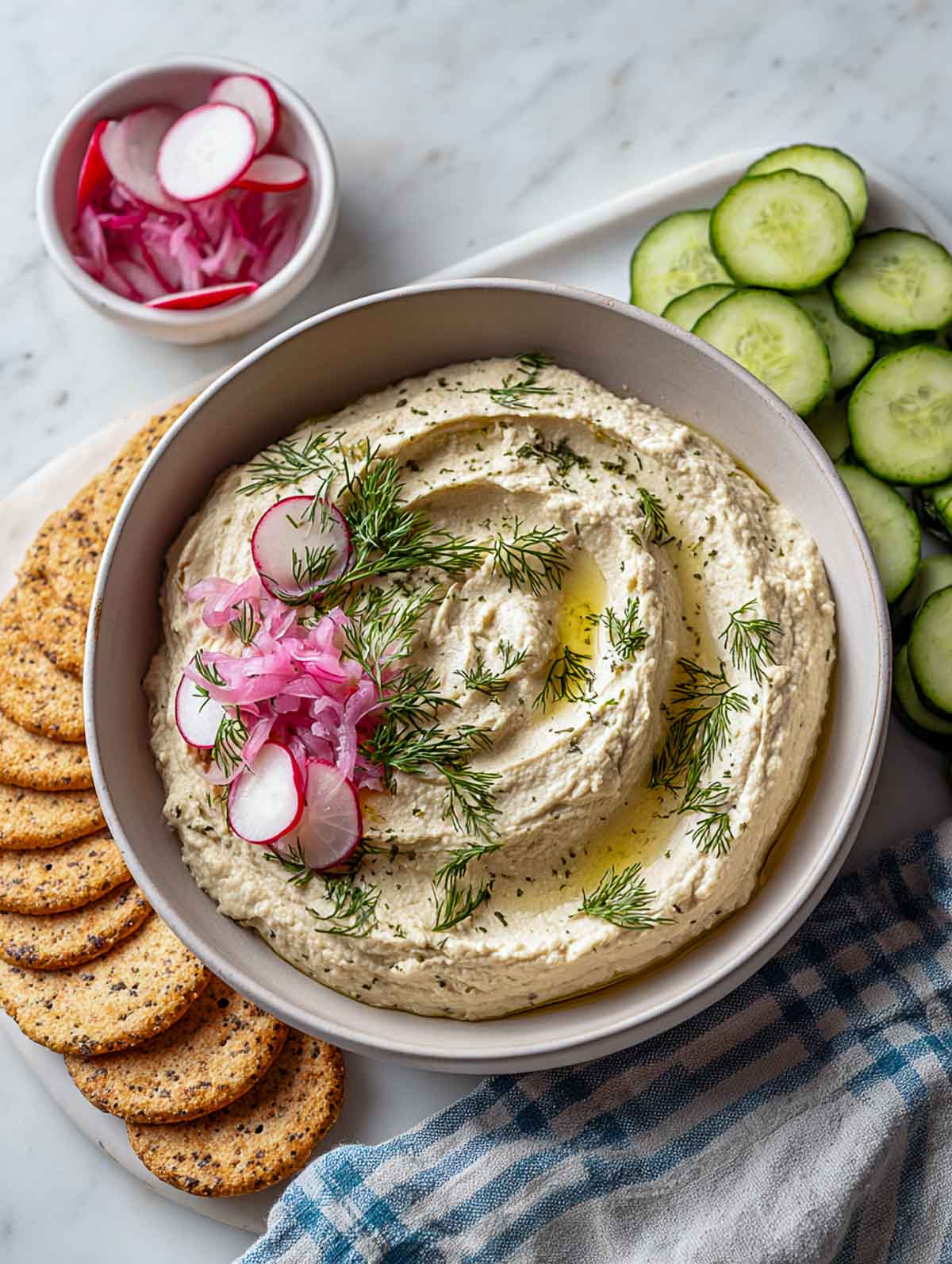 Navy bean dip with dill and pickled onion served with crackers.