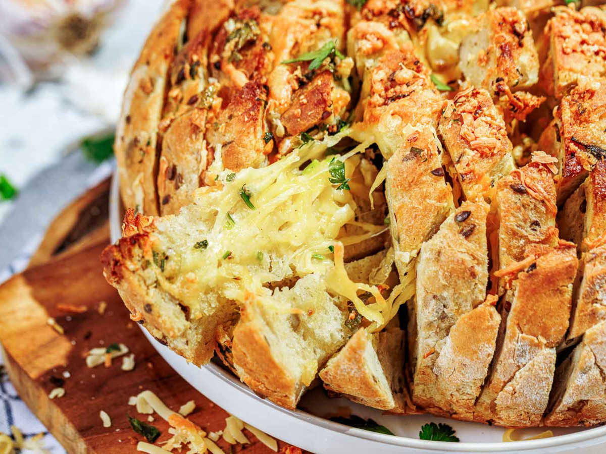 Cheesy pull apart garlic bread on a white serving plate.
