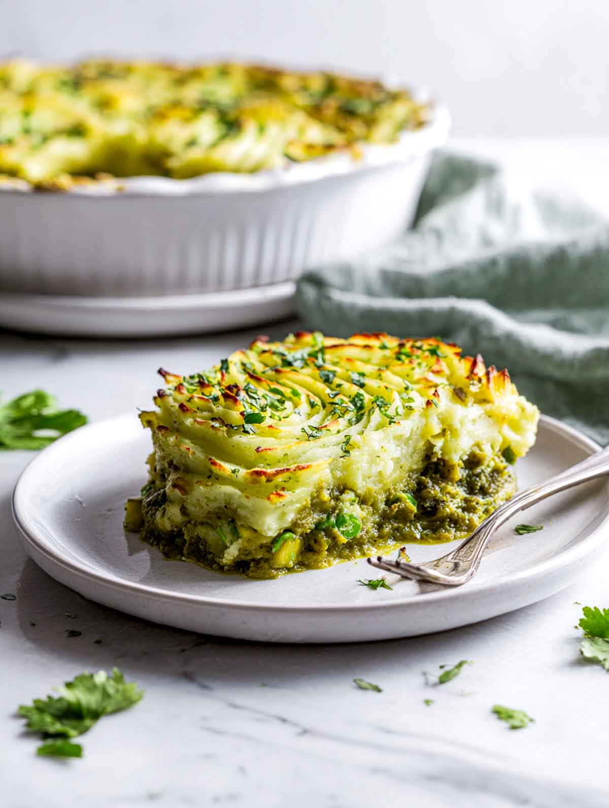 A plated scoop of green curry shepherd’s pie showing the creamy green filling.