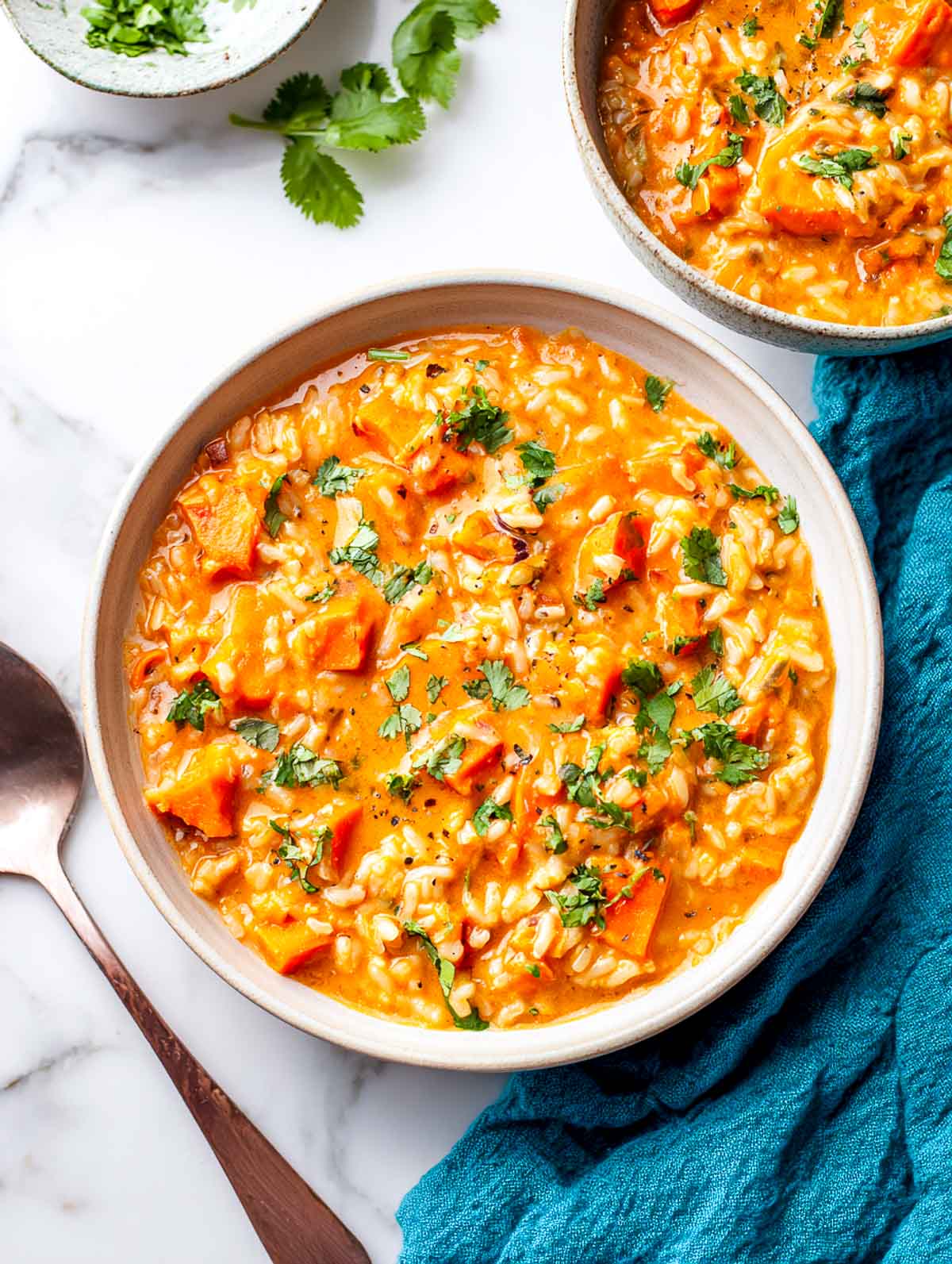 Sweet potato peanut rice cooker stew with rice and cilantro in a ceramic bowl.