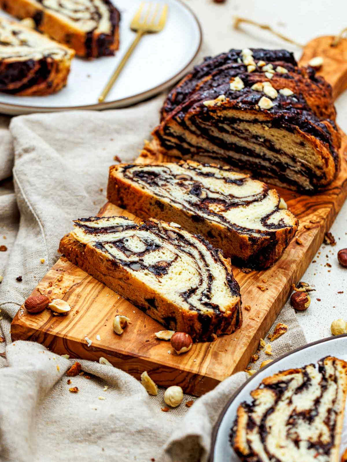 Thick slices of chocolate hazelnul babka placed on a wooden board.