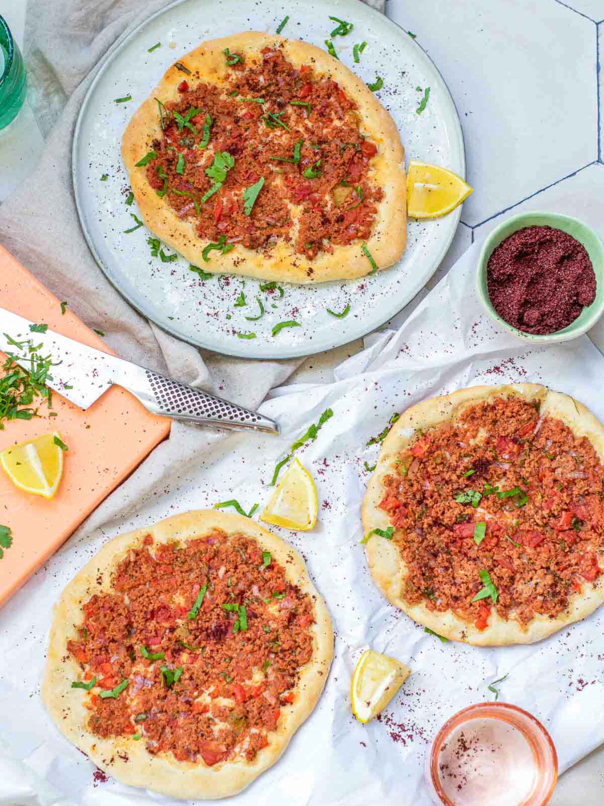 Turkish lahmacun served on a white plate and marble surface.