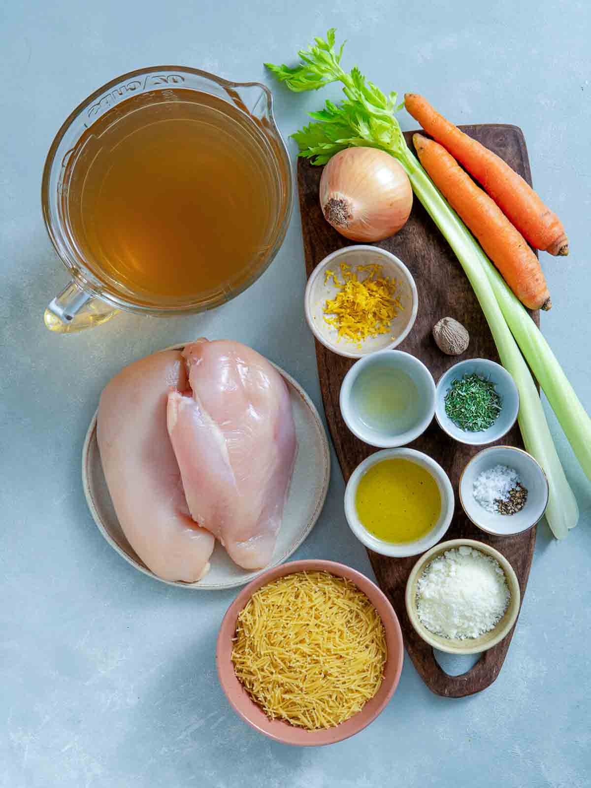 Chicken fideo soup ingredients including chicken breast, broth, carrots, celery, onion, vermicelli pasta, and seasonings.