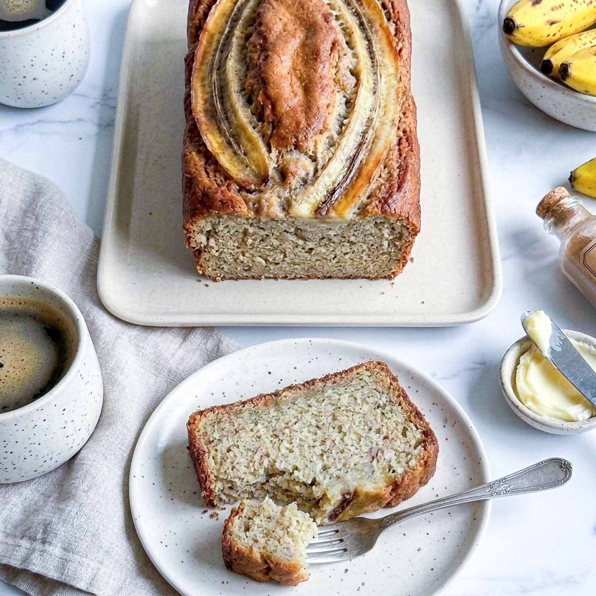 Fork cutting into a slice of moist high protein kefir banana bread showing the soft crumb texture.