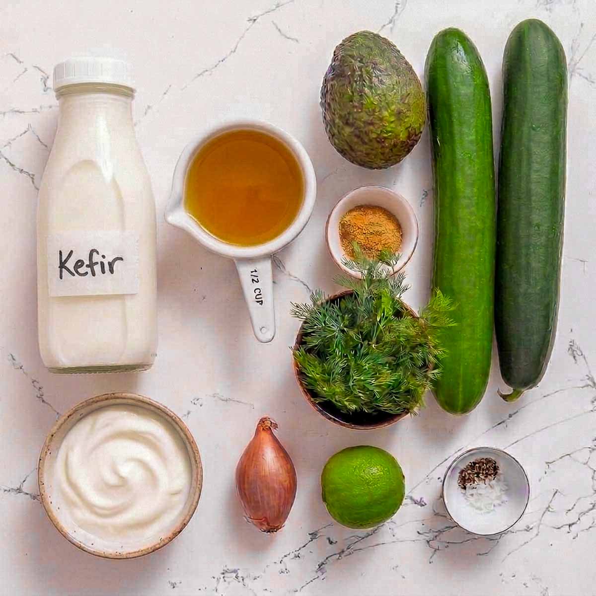 Ingredients for kefir cucumber avocado soup including kefir, cucumbers, avocado, Greek yogurt, dill, shallot, lime, broth, and seasonings.