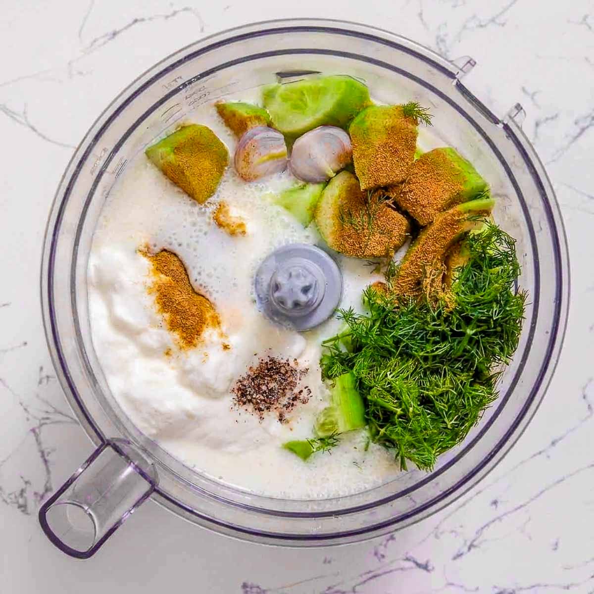 Kefir, cucumber, avocado, Greek yogurt, dill, shallot, and seasonings added to a food processor before blending.