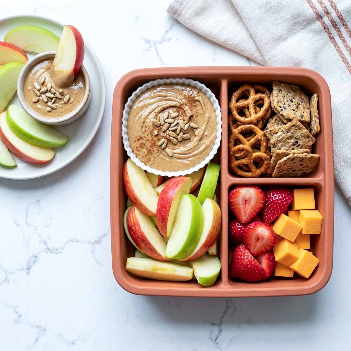 SunButter apple dippers with sliced apples, pretzels, whole-grain crackers, strawberries, and cheese cubes.