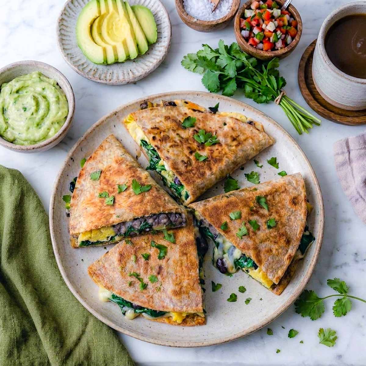 Top view of freezer breakfast quesadillas cut into wedges on a speckled plate.