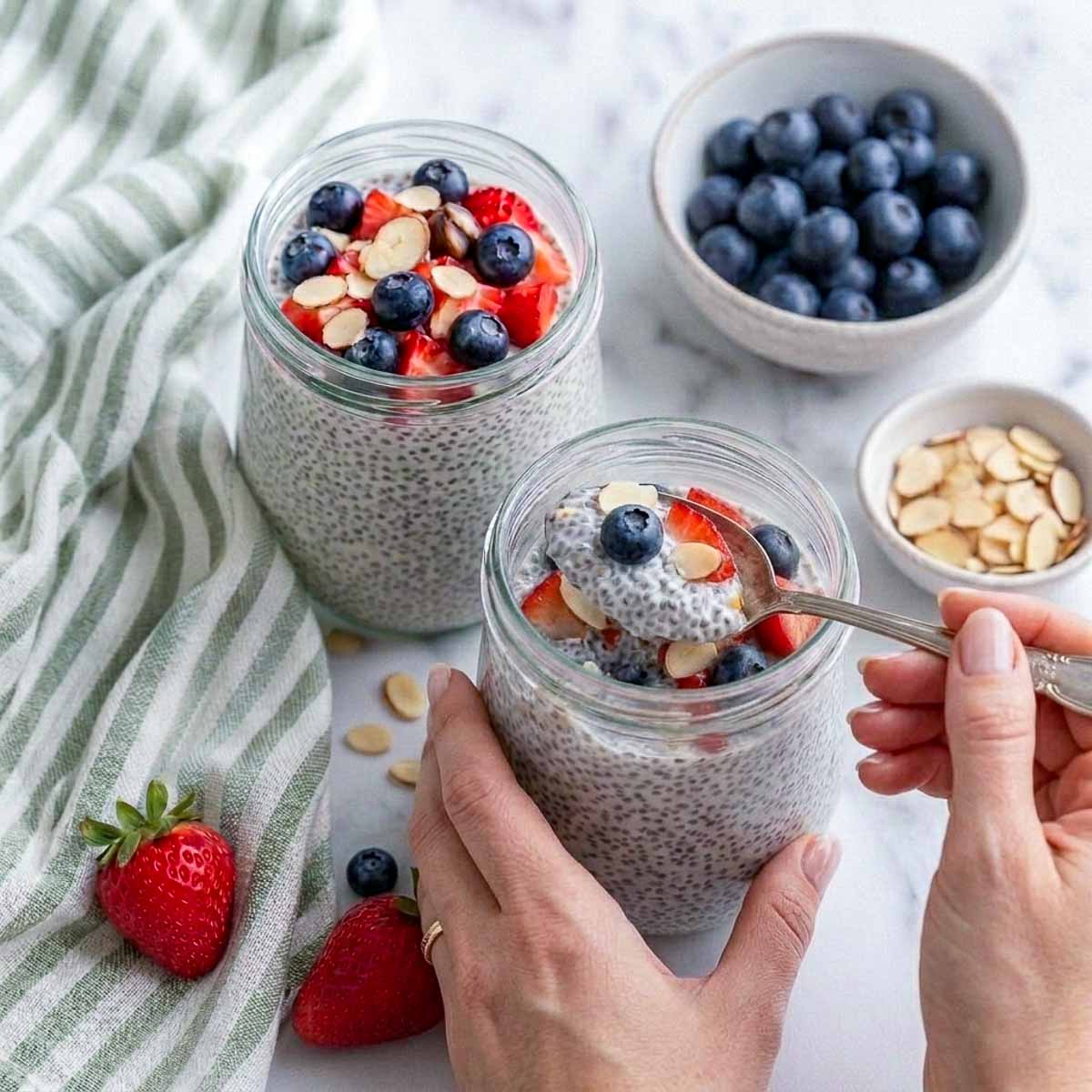 A spoonful of thick kefir chia pudding lifted from the jar, showing the creamy set and whole berries.