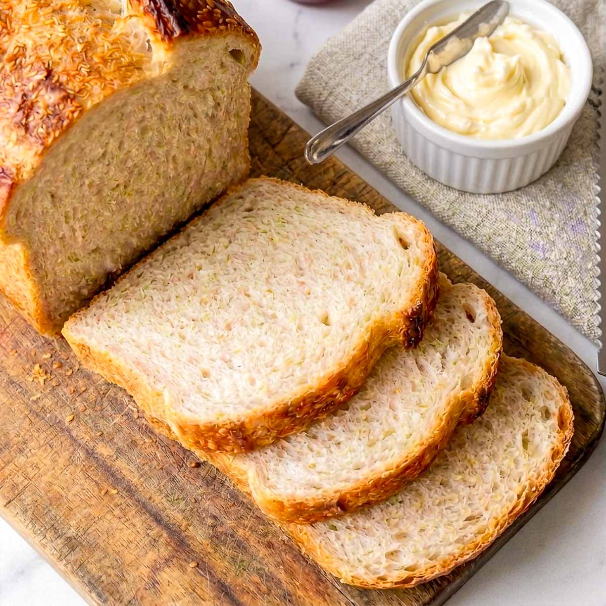 Close up of sourdough sandwich bread sliced and placed on a wooden board.