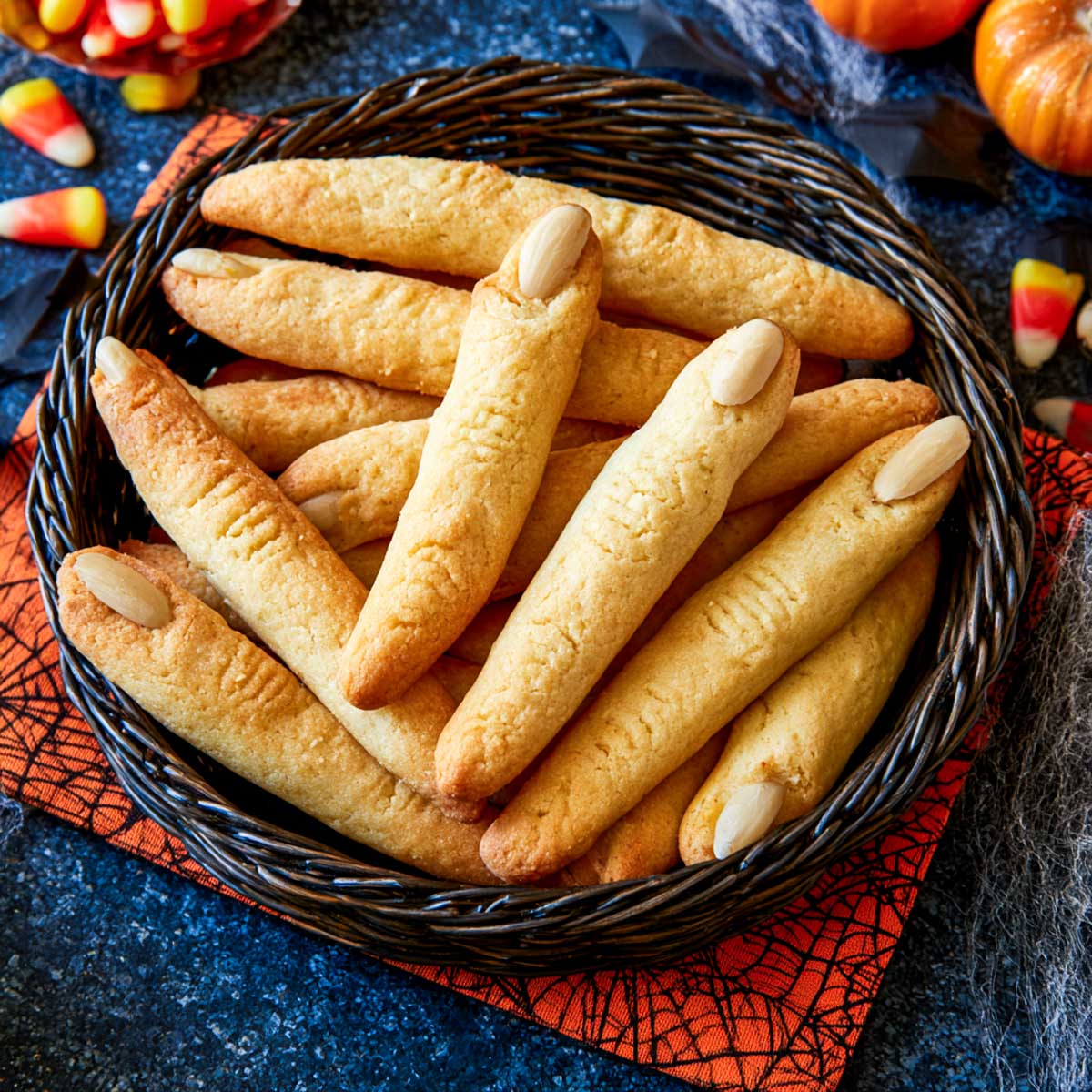 Basket of witch finger breadsticks with blanched almond nails and knuckle score marks.