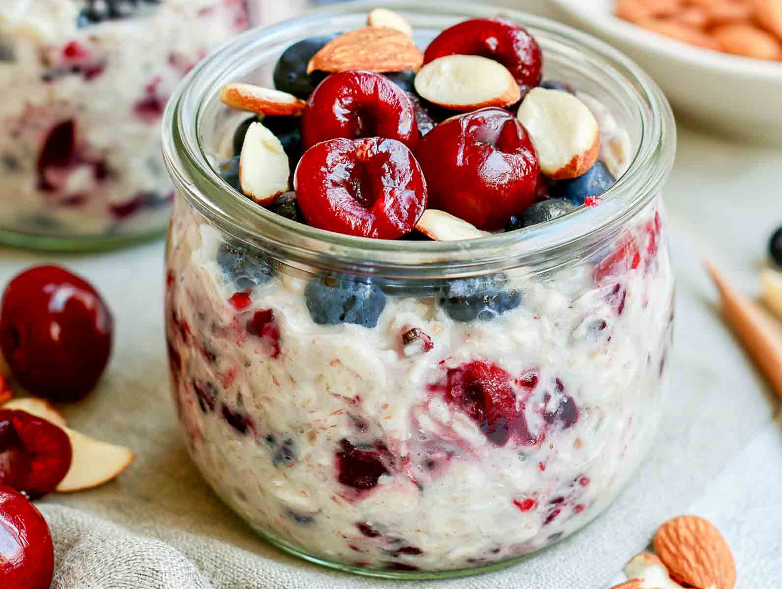 Cherry almond kefir overnight oats topped with fresh cherries, blueberries, and chopped almonds.