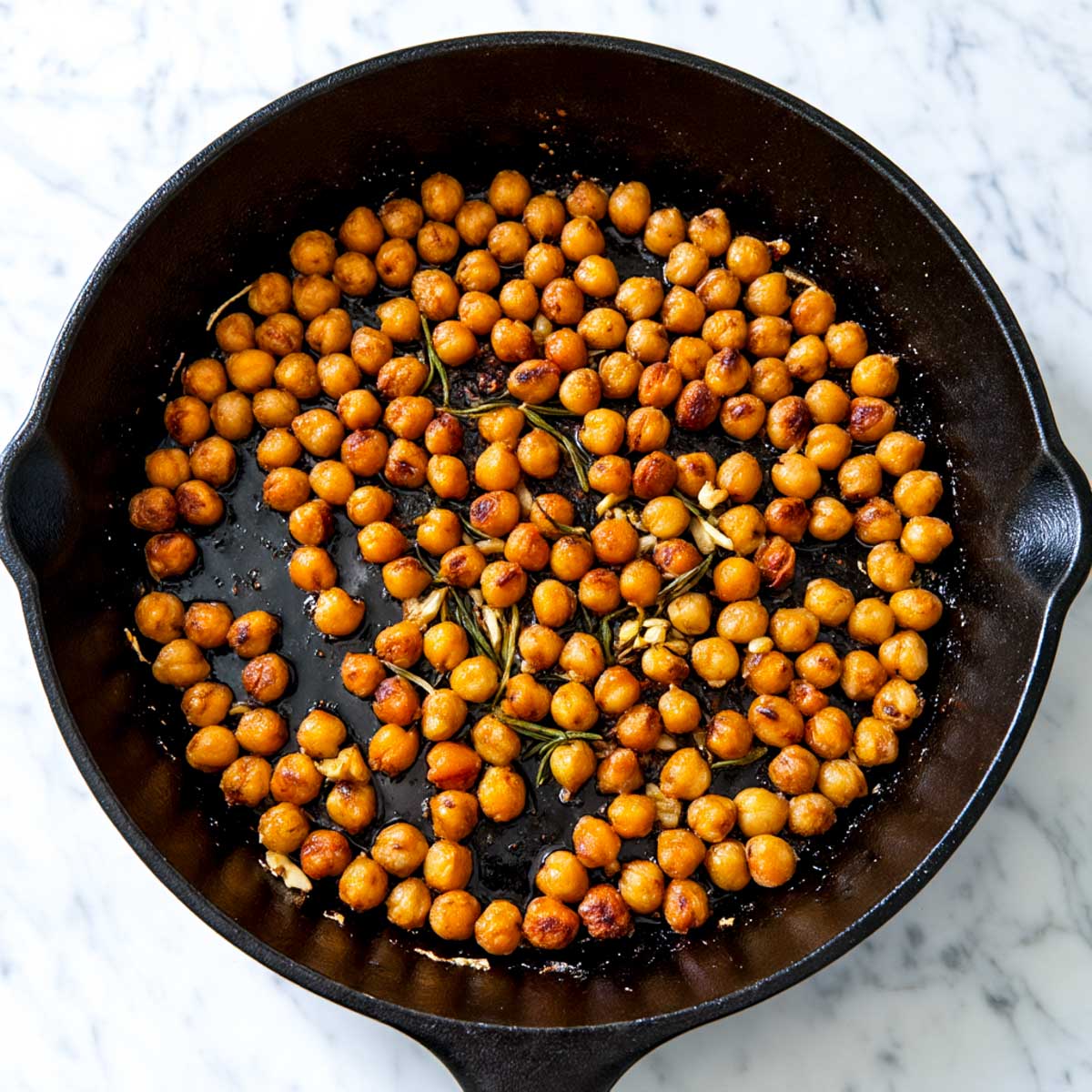 Chickpeas are seasoned with garlic, rosemary, dried herbs, and spices before being cooked for the fried eggs.