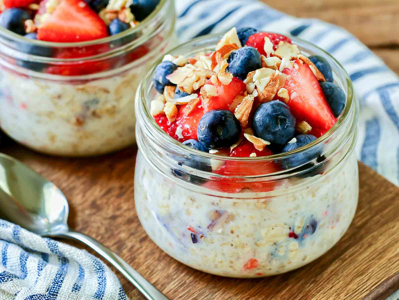 Coconut berry kefir overnight oats in a jar topped with strawberries, blueberries, and chopped almonds.